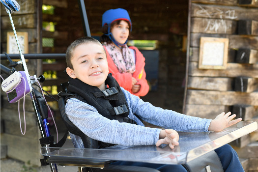 Un enfant en fauteuil posant devant l'objectif