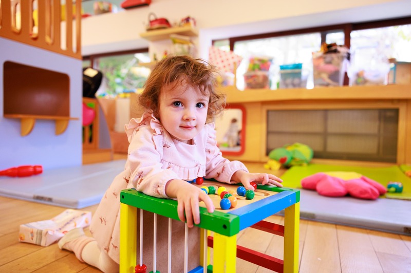 Enfant jouant avec un boulier coloré dans une salle de jeux lumineuse et bien équipée, symbolisant les projets soutenus par Viva for Life pour aider l'enfance en situation de précarité. - Viva for Life conférence de presse du 21 mars 2024 - en 2024 Viva for Life aide 185 projets